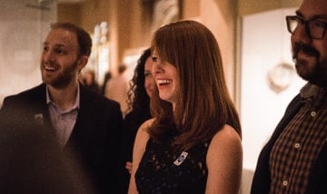 A group of VIP museum tour guests laughing.